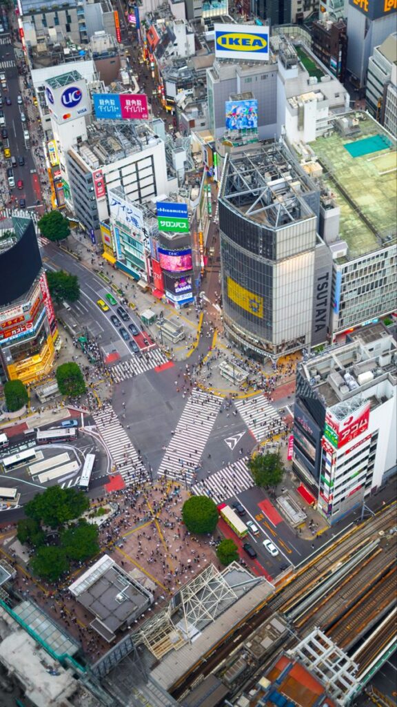 Aerial view of Shibuya Crossing surrounded by skyscrapers.